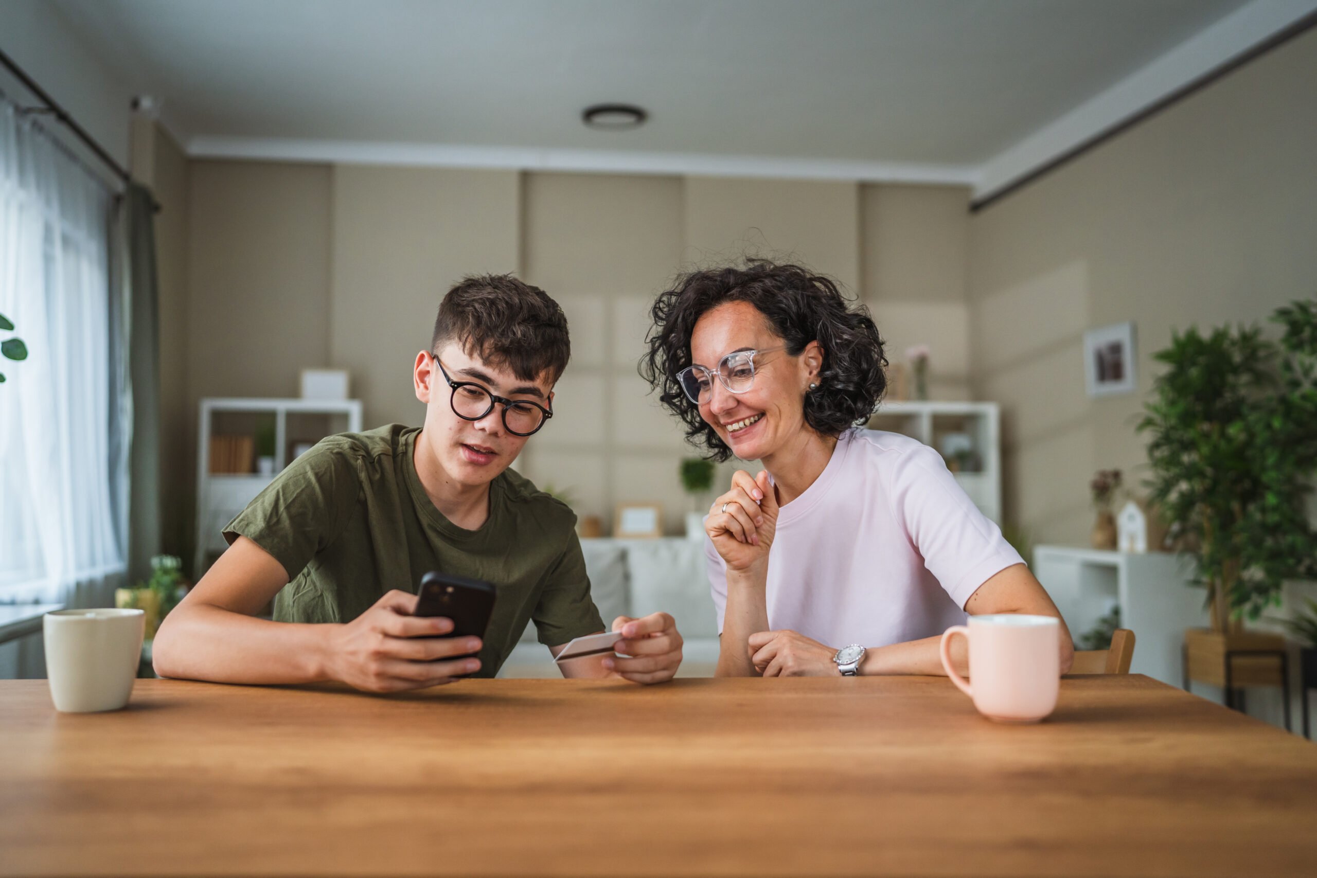 Mom and son sitting together while using smartphone